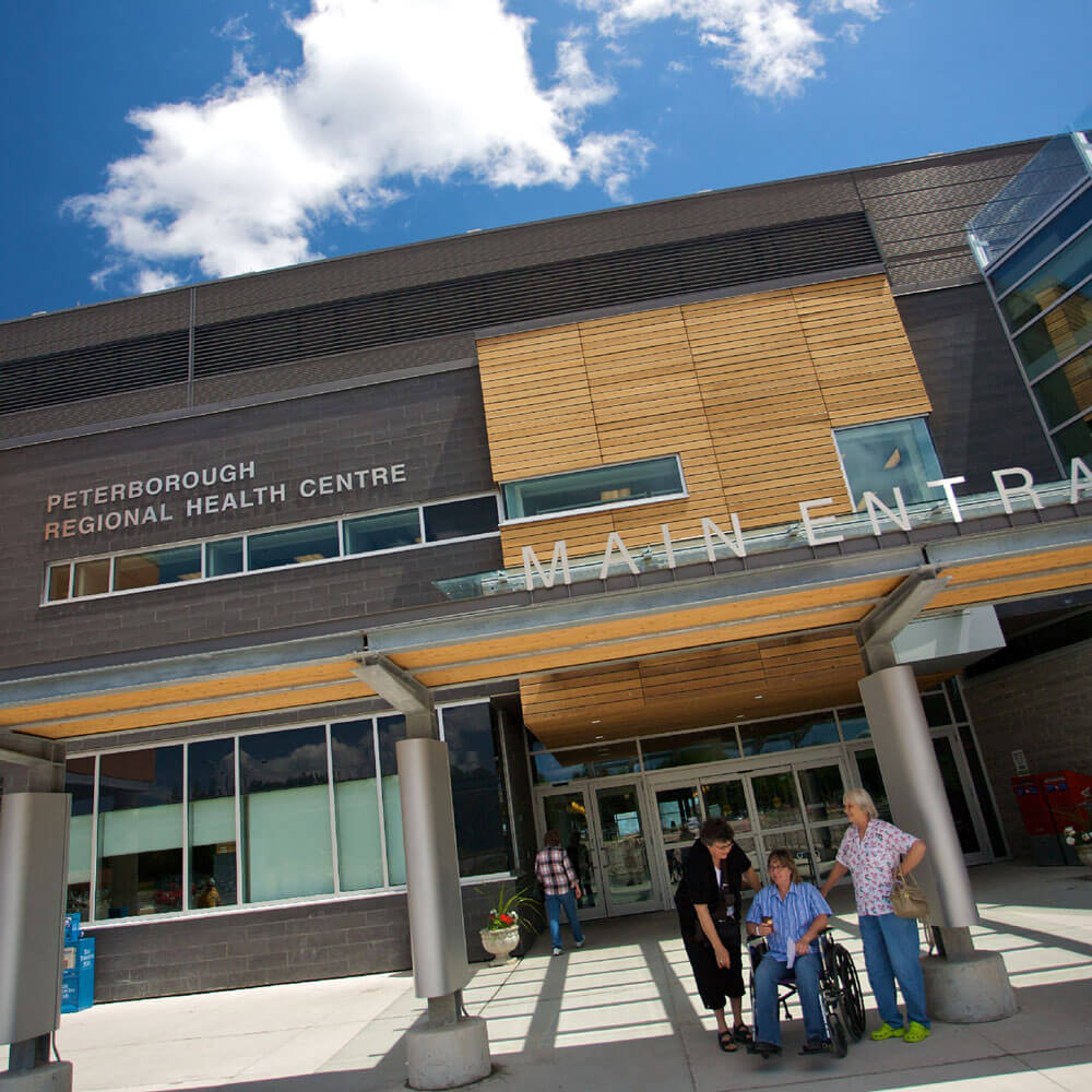 Exterior of the PRHC main entrance with people waiting for pickup
