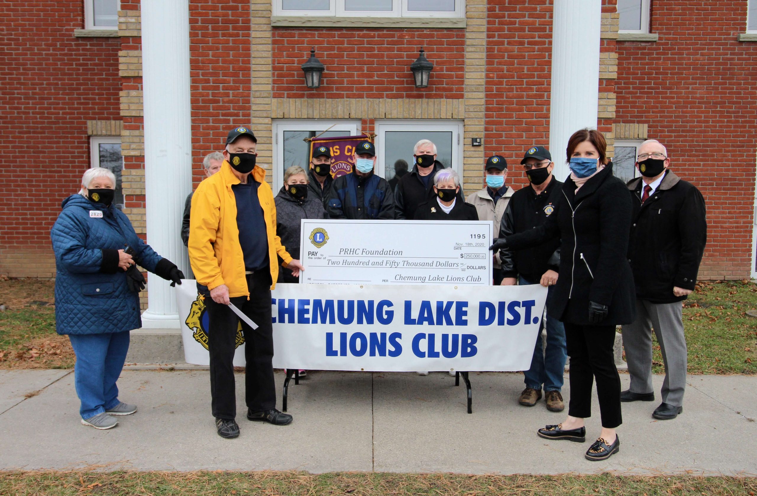 Lions Club member presents a large cheque