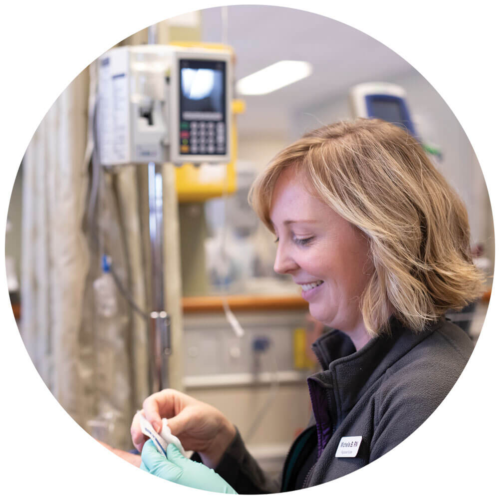 Happy nurse preparing needle for chemo therapy treatment