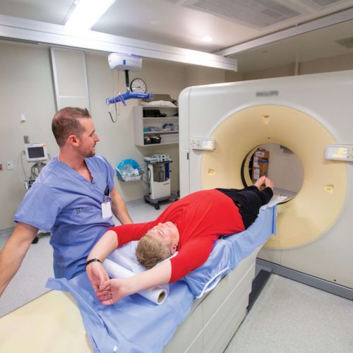 A Medical Radiation Technologist and volunteer demonstrate a CT scanner