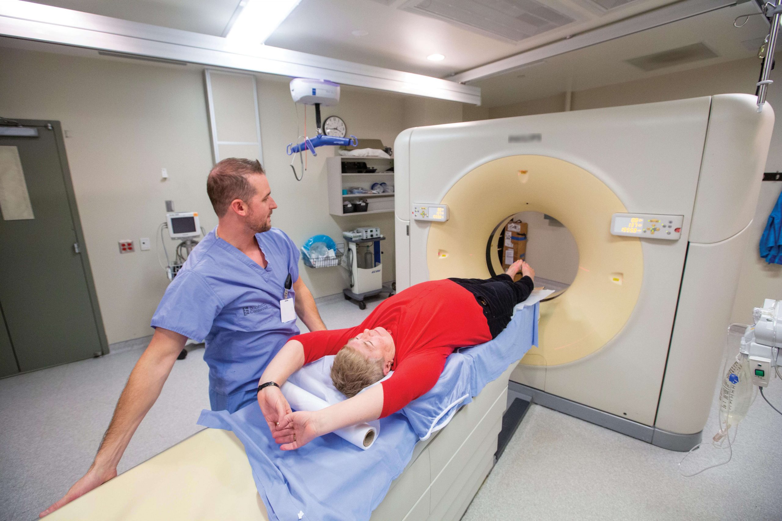 A Medical Radiation Technologist and volunteer demonstrate a CT scanner