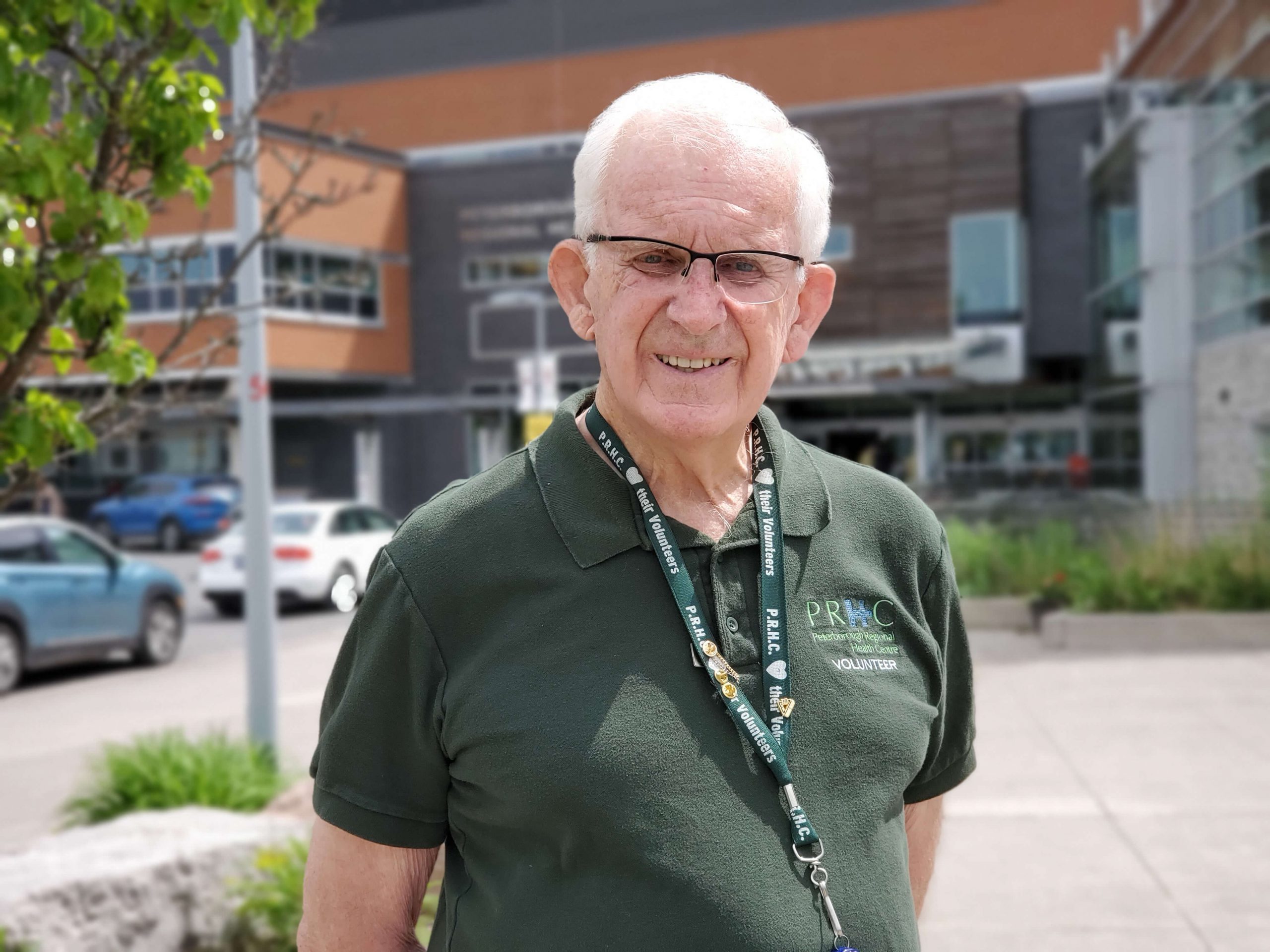 A volunteer stands in front of the hospital's main entrance