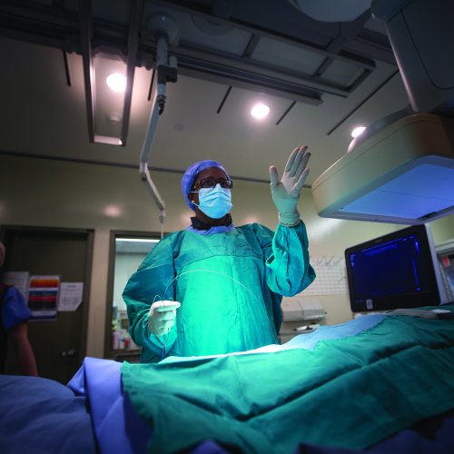 A doctor performs a minimally invasive interventional radiology procedure.