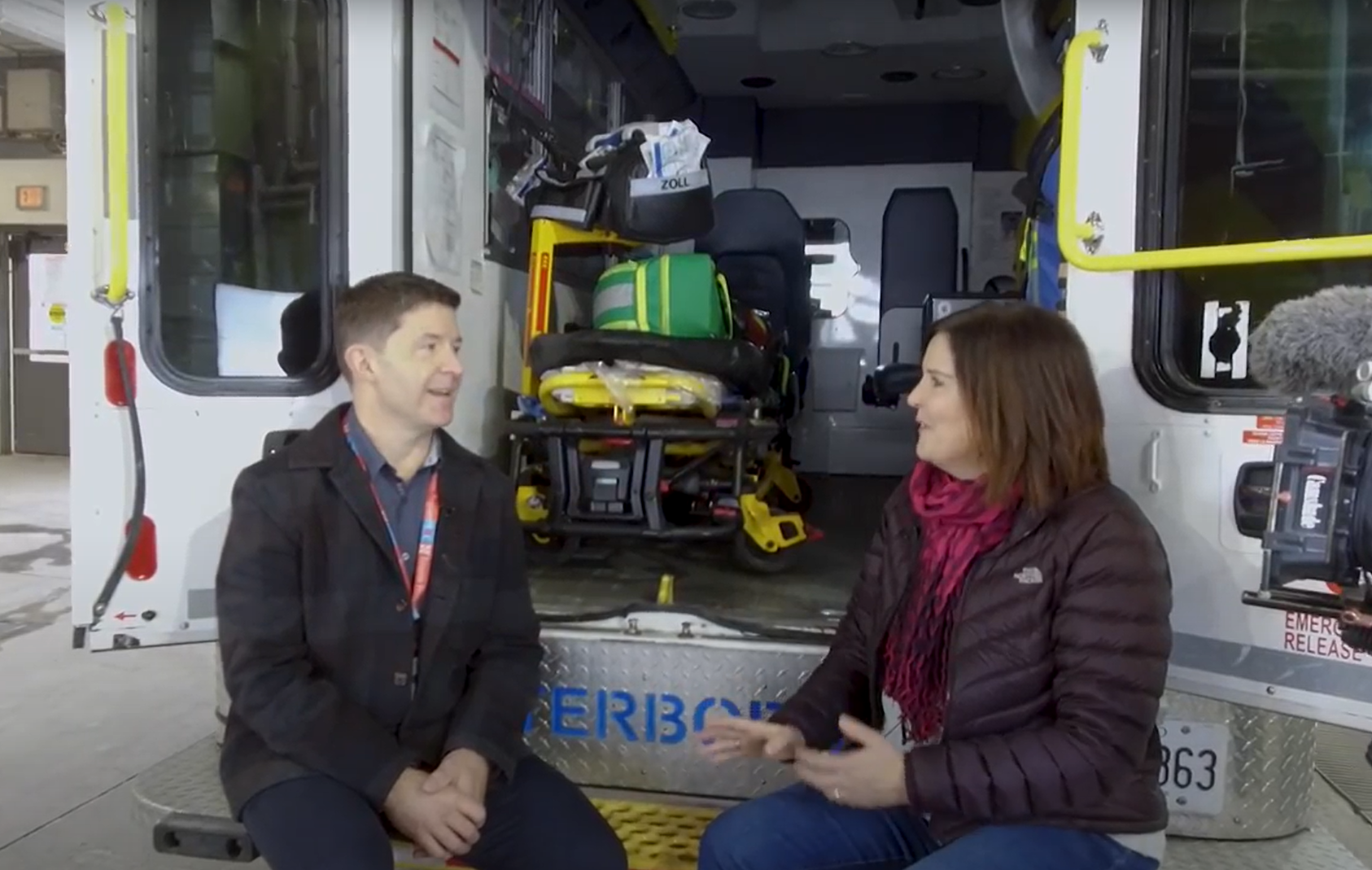 Dr. Troy Tebbenham and PRHC Foundation President & CEO, Lesley Heighway, sit and talk on the back of an ambulance